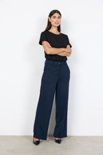 Load image into Gallery viewer, Woman wearing a black top and navy wide-leg pants against a white background