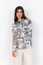 Load image into Gallery viewer, Woman wearing a floral/palm tree navy and white blouse with a white background