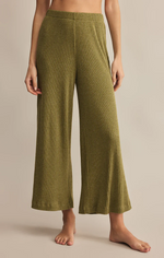 Load image into Gallery viewer, Green ribbed pants worn by a person on a beige background