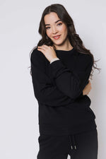 Load image into Gallery viewer, Woman wearing a black crewneck sweatshirt against a white background