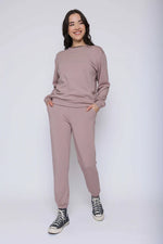 Load image into Gallery viewer, Woman wearing a matching pink sweater and pants set on a white background