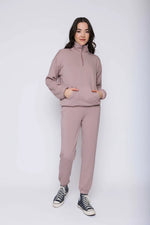 Load image into Gallery viewer, Woman wearing a pink 1/2 zip sweatshirt and matching joggers with black sneakers on a white background