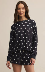 Load image into Gallery viewer, Woman wearing a black pajama set with white ghost patterns on a beige background