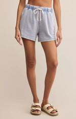 Load image into Gallery viewer, Washed indigo knit denim shorts worn by a person on a beige background