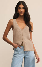 Load image into Gallery viewer, Woman wearing a beige knitted vest and light blue jeans against a neutral background