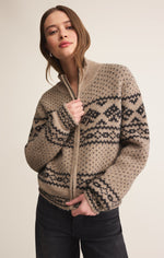 Load image into Gallery viewer, Woman wearing a beige zip up cardigan sweater with a geometric pattern, standing against a plain background