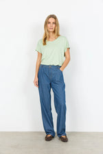 Load image into Gallery viewer, Woman wearing a light green t-shirt and blue striped pants against a white background
