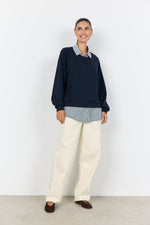 Load image into Gallery viewer, Women wearing a navy sweater with a faux navy and white blouse underneath. 
