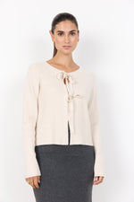 Load image into Gallery viewer, Cream cardigan designed with a ribbed texture, open front, and tie closures.
