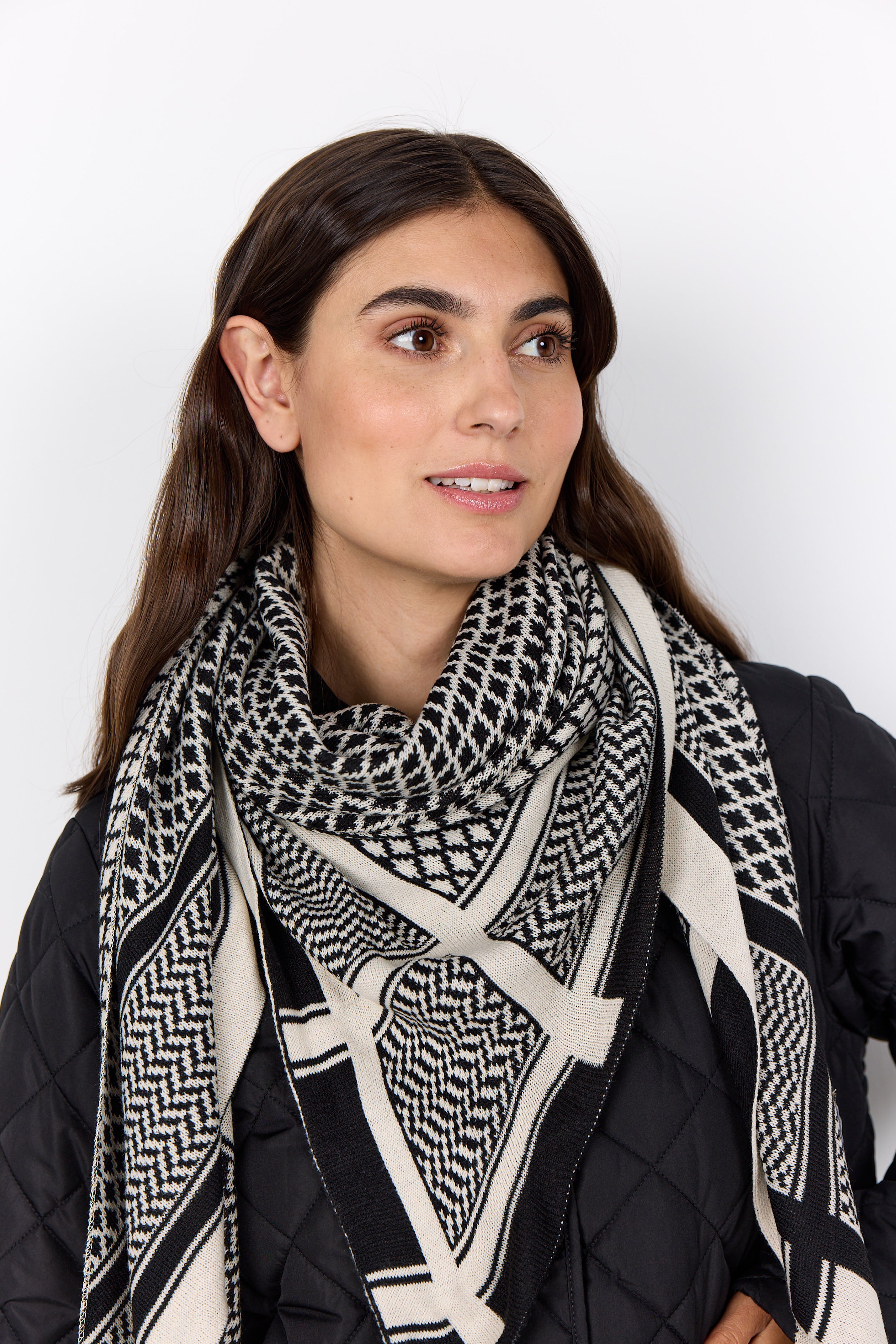 Woman wearing a black and white patterned scarf on a white background