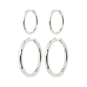 Set of silver hoop earrings on a white background. Huggie closure. 