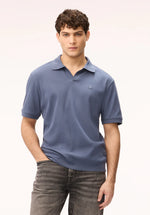 Load image into Gallery viewer, Man wearing a blue knit polo shirt and jeans on a white background
