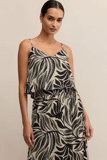 Load image into Gallery viewer, Woman wearing a black and white leaf patterned dress against a beige background
