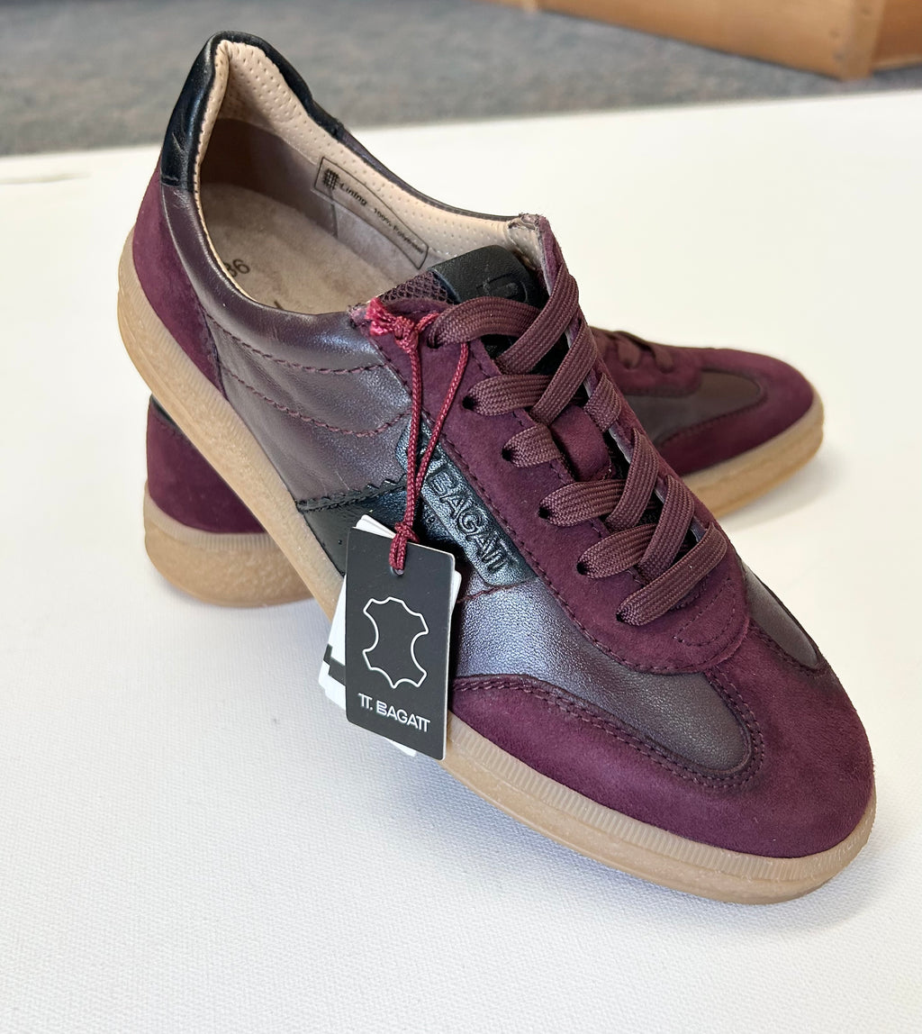 Pair of maroon sneakers on a white surface