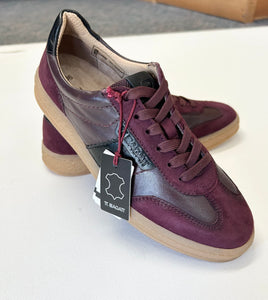 Pair of maroon sneakers on a white surface