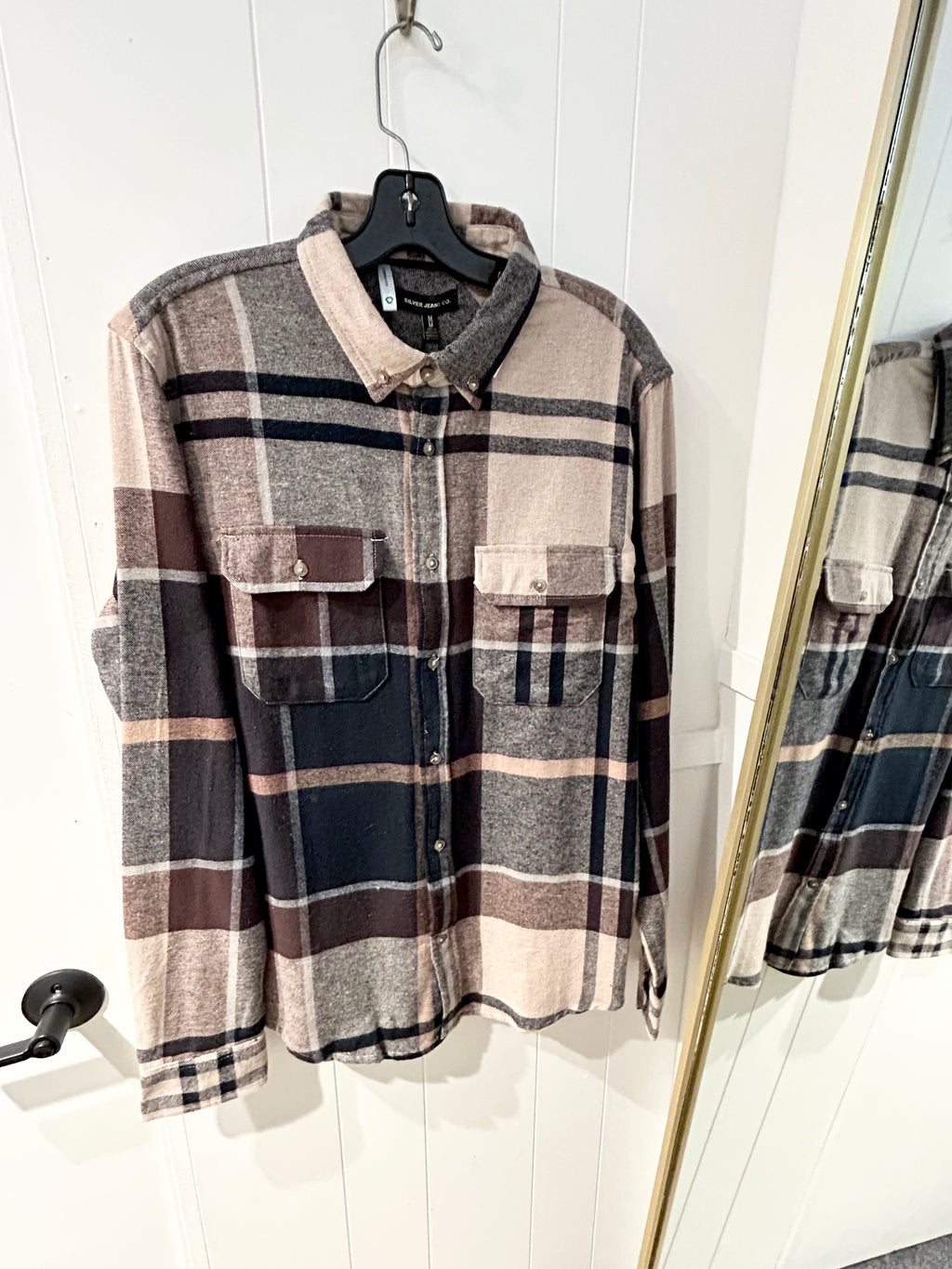 Plaid shirt on a hanger against a white wall