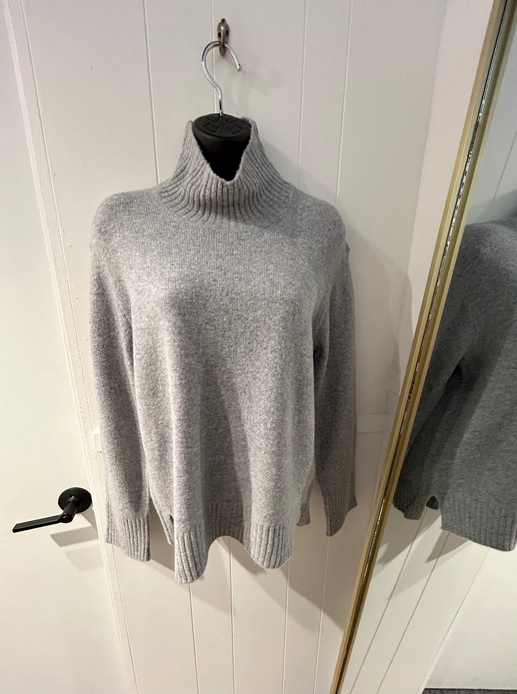 Grey turtleneck sweater with rib detail on cuffs, bottom hem, and neck. 