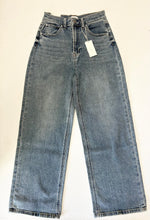 Load image into Gallery viewer, Pair of blue jeans with a tag on a white background
