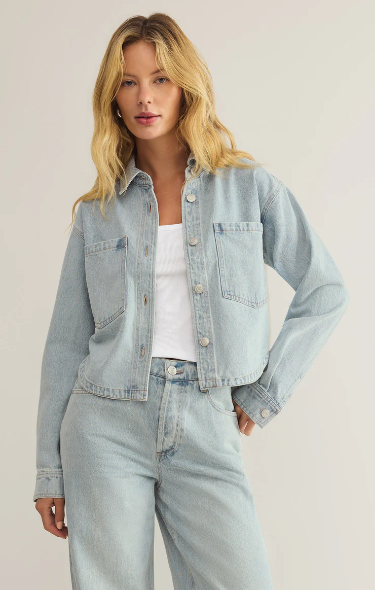 Light denim jacket with button closure, and breast pockets. Cropped length, sits above the hips. 