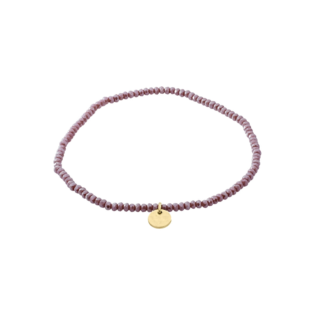 Purple beaded bracelet with a gold tag on a white background