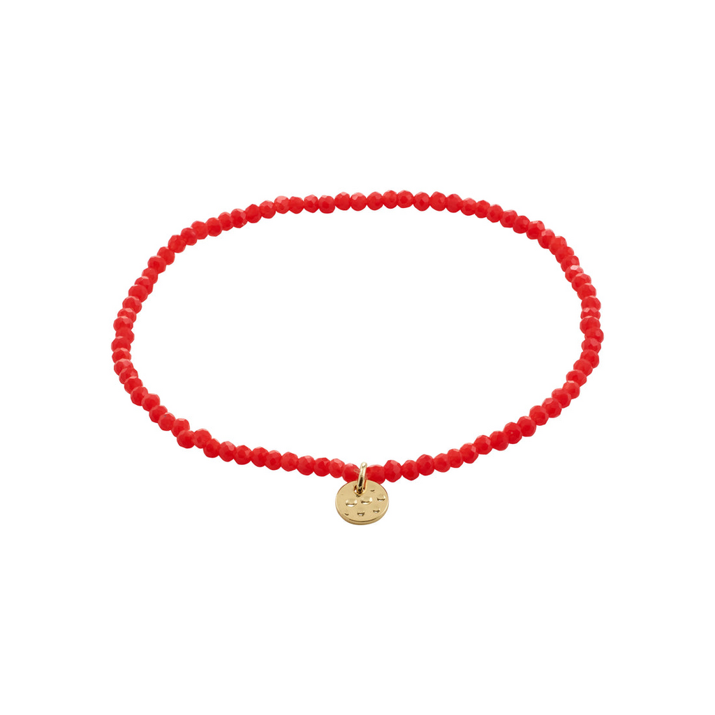Red beaded bracelet with a gold charm on a white background