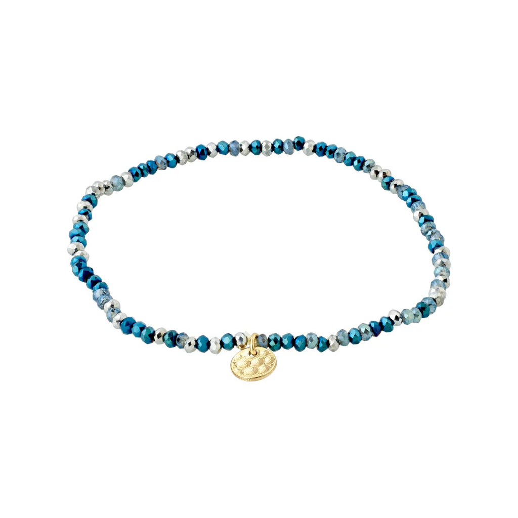 Blue beaded bracelet with a gold charm on a white background