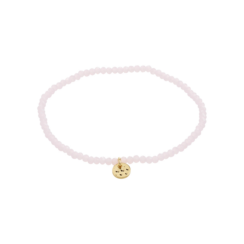 Pink beaded bracelet with a gold charm on a white background
