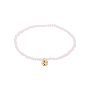 Pink beaded bracelet with a gold charm on a white background