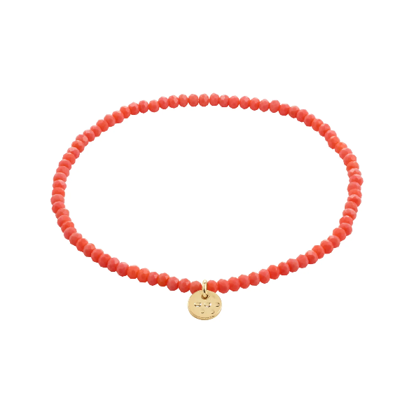 Peach beaded bracelet with a gold tag on a white background
