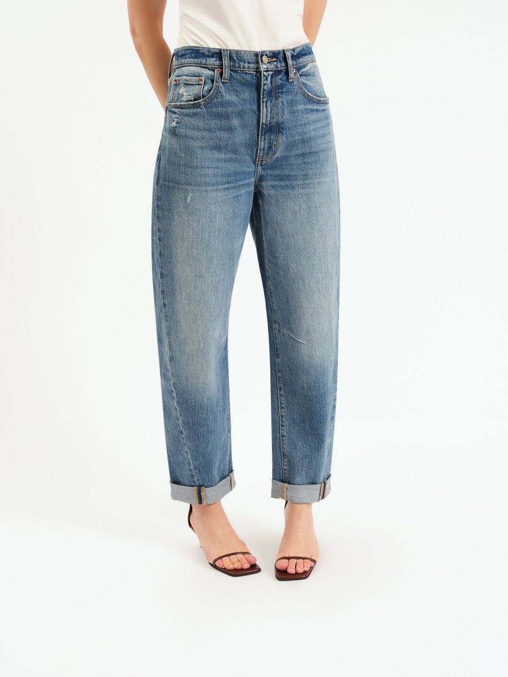Blue jeans with a high rise barrel leg featuring a pre-rolled cuff