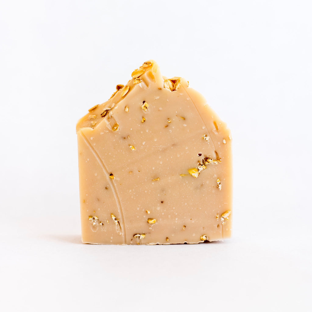 Bar of soap with visible oats on a white background