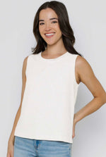 Load image into Gallery viewer, Woman wearing a white sleeveless top and blue jeans against a plain background
