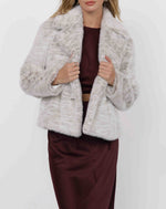 Load image into Gallery viewer, Woman wearing a light gray faux fur  jacket over a burgundy outfit on a white background
