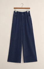 Load image into Gallery viewer, Blue knit denim wide-leg pants on a hanger against a beige background
