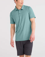 Load image into Gallery viewer, Man wearing a teal polo shirt and black shorts on a light gray background
