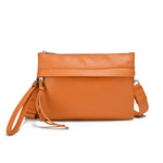 Load image into Gallery viewer, Orange vegan leather clutch with optional crossbody strap. 
