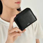 Load image into Gallery viewer, Person holding a black vegan leather wallet with 'Co Lab' branding against a neutral background
