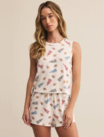 Load image into Gallery viewer, Woman wearing a sleeveless top and shorts with football pattern on a beige background
