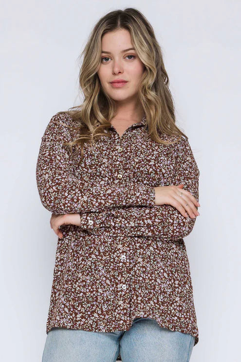 Woman wearing a brown floral blouse against a white background
