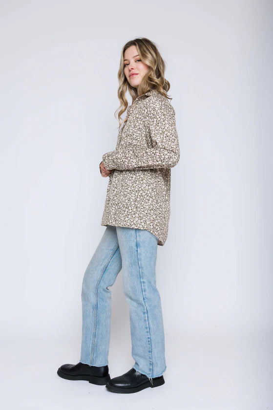 Woman wearing a green pattern blouse. 