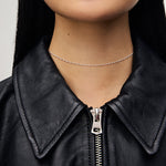 Load image into Gallery viewer, Person wearing a black leather jacket with a zipper, showcasing a silver necklace.
