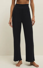 Load image into Gallery viewer, Black ribbed fit and flare lounge pants worn by a person on a plain background
