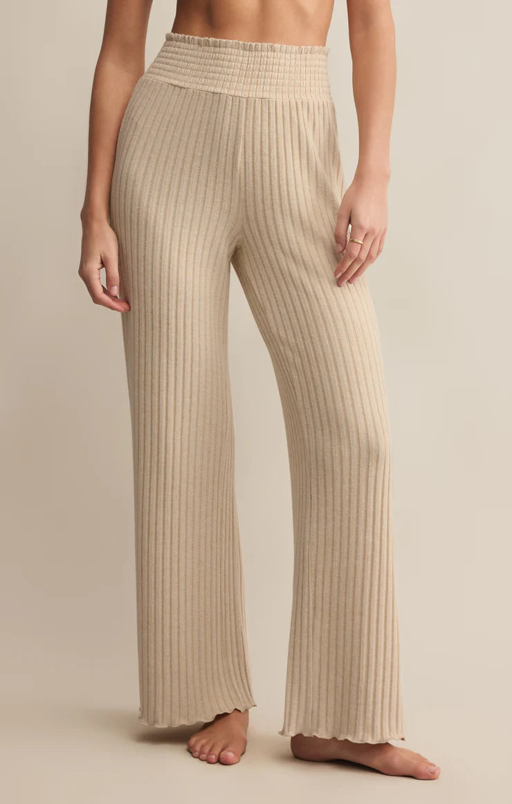 Beige ribbed pants worn by a person on a beige background