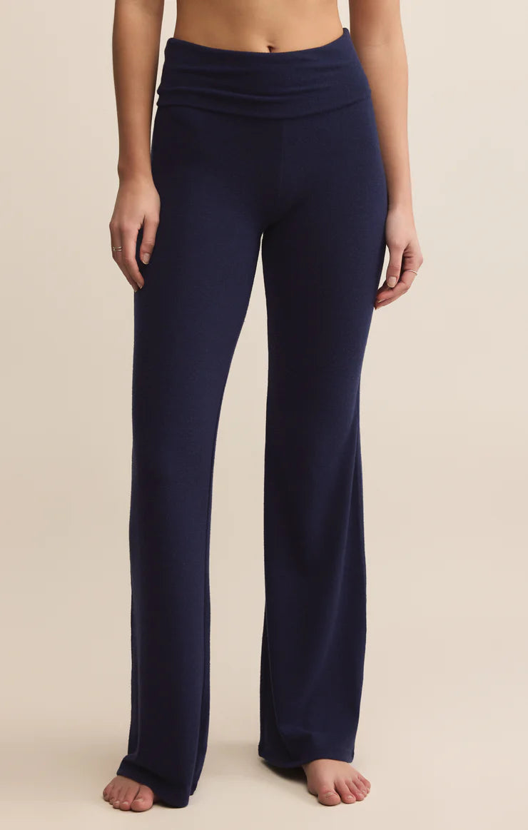 Navy blue yoga pants worn by a person on a beige background
