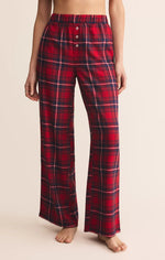 Load image into Gallery viewer, Red plaid flannel pants worn by a person on a beige background
