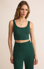 Load image into Gallery viewer, Woman wearing a green ribbed  lounge tank bra and ribbed lounge pants on a beige background
