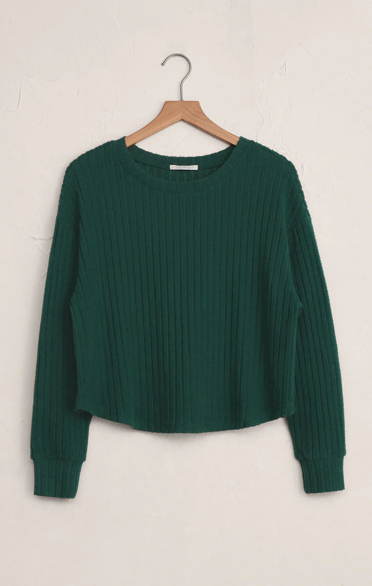 Green ribbed sweater on a wooden hanger against a white background