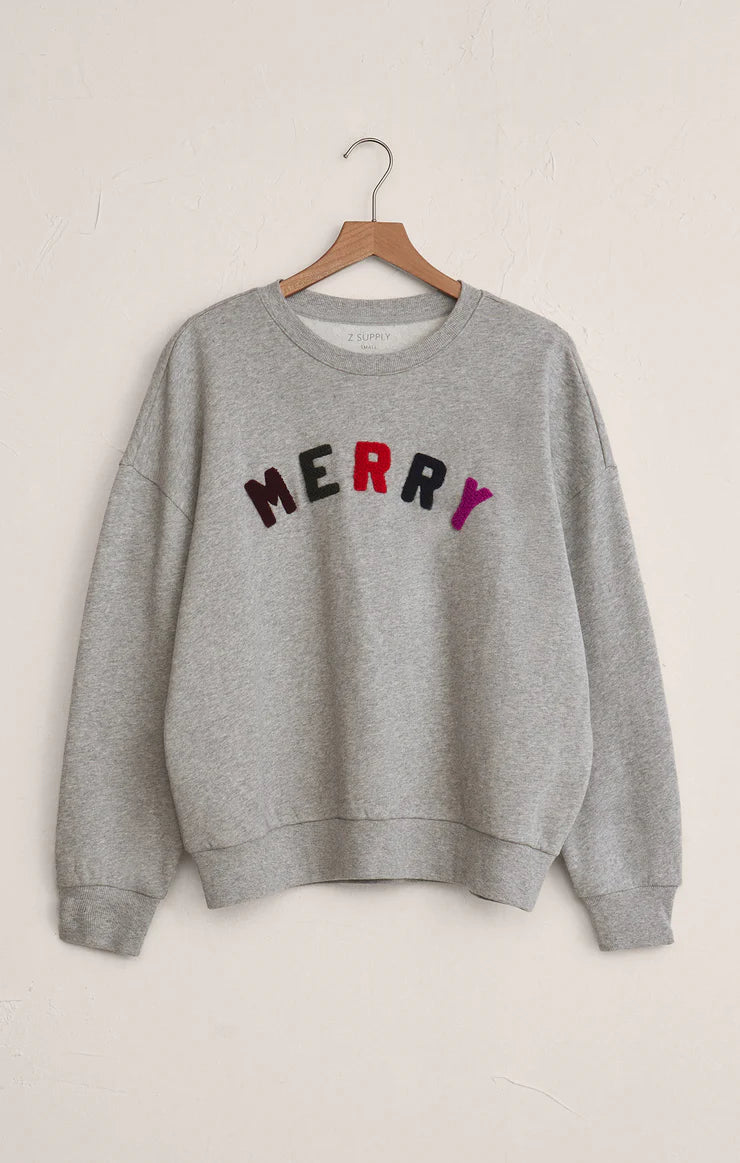 Gray sweatshirt with 'MERRY' in colorful letters on a beige background
