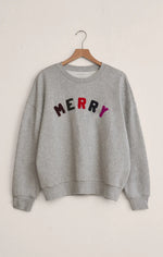 Load image into Gallery viewer, Gray sweatshirt with &#39;MERRY&#39; in colorful letters on a beige background
