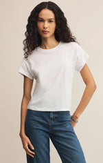Load image into Gallery viewer, Woman wearing a white t-shirt and blue jeans against a beige background
